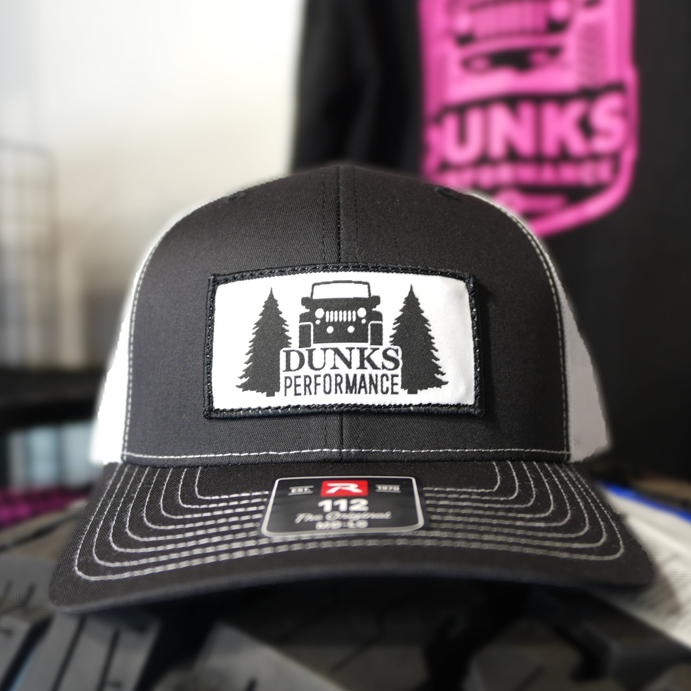 Black cap with Dunks Performance logo on a blurred background