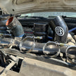 S&B hot side intercooler boots and T-bolt clamps resting on the engine bay of a Ford 6.0L Powerstroke